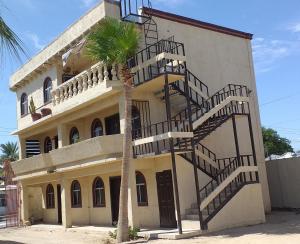 een gebouw met een wenteltrap naast een palmboom bij Departamento Irene in San Felipe