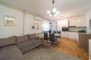 a living room with a couch and a kitchen at Apartment Trešnja in Zagreb