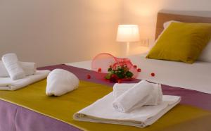 a hotel room with towels and flowers on a bed at Hotel Sikania in San Vito lo Capo