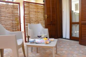a table with two glasses of wine on a patio at Hotel Sikania in San Vito lo Capo