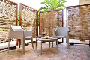two chairs and a table in a room with windows at Hotel Sikania in San Vito lo Capo