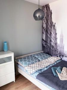 a bedroom with a bed with a mural of a city at Apartament 47 Letnica in Gdańsk