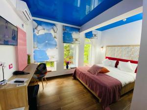 1 dormitorio con 1 cama, escritorio y 2 ventanas en MAREA NEAGRA Executive Rooms, en Mamaia