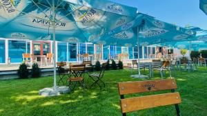 a group of tables and chairs under blue umbrellas at HOTEL MAREA NEAGRA Mamaia in Mamaia