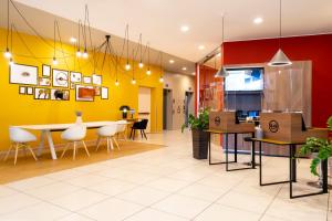 comedor y cocina con paredes amarillas y rojas en B&B Hotel Milano-Monza en Monza