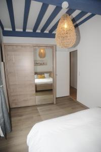 Schlafzimmer mit einem weißen Bett und einem Spiegel in der Unterkunft Au colombage bleu 2 à 4 pers in Dieppe