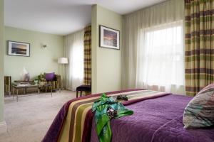 a bedroom with a bed with a purple blanket at Palm Grove Apartments in Torquay