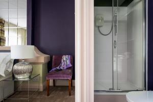 a bathroom with a shower and a chair and a lamp at Palm Grove Apartments in Torquay +82 photos
