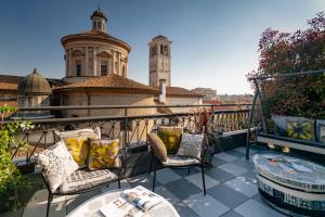 a balcony with chairs and a table and a building at B&B Hotel Milano Sant'Ambrogio in Milan