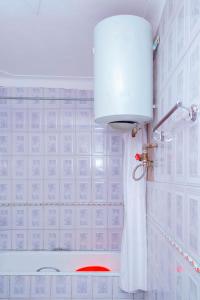 baño con ducha con cortina blanca en Kijungu Hill Hotel Hoima, en Hoima