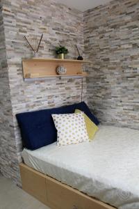 Casa Angelina Deluxe Suite في ليتشي: سرير في غرفة بجدار من الطوب