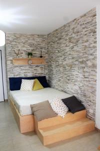 a bed in a room with a brick wall at Casa Angelina Deluxe Suite in Lecce