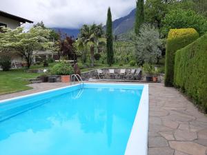 a swimming pool in a yard with a house at Obermaratscher Apartments Residence in Lagundo
