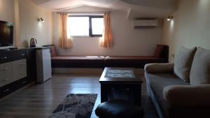 a living room with a couch and a window at Guest House Bulgari in Kazanlŭk