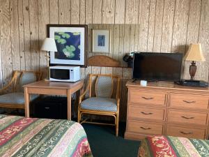 a hotel room with a television and a bed and a desk at Glendale Motel in Seaside Heights
