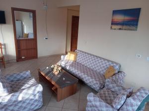 a living room with a couch and two chairs at Jonny Guesthouse in Ksamil