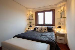 Habitación pequeña con cama y ventana en Mirante do Quinta 705 - My Home Temporada, en Canela
