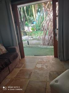 uma sala de estar com uma porta aberta para um quintal em Pousada Yuste Beach Farm em Paracuru