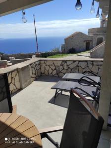 a patio with a table and chairs and the ocean at Lubenice-Rodinis Room and Apartment in Lubenice