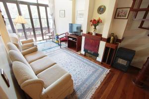 sala de estar con sofá y TV en Ravena - My Home Temporada, en Gramado