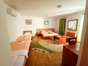 a small room with two beds and a table at Hotel Porto Bello in Trebinje