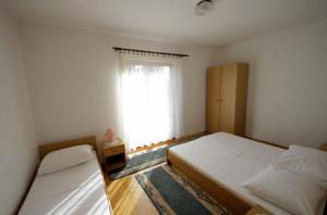 a bedroom with two beds and a window at APARTMENTS Vuković in Vrboska