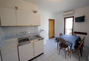 a kitchen with a table and a kitchen with a table and chairs at APARTMENTS Vuković in Vrboska