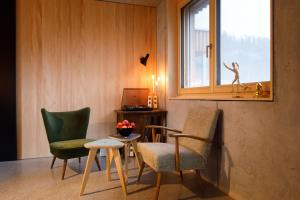 a room with two chairs and a table and a window at Stud!o 8 in Bezau