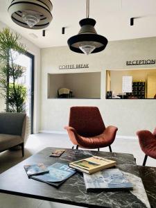 a living room with a coffee table and a chair at Hotel Marolda in Sirmione