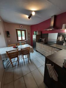 Gîte la maison de Mika في Saint-Floret: مطبخ مع طاولة وكراسي في غرفة