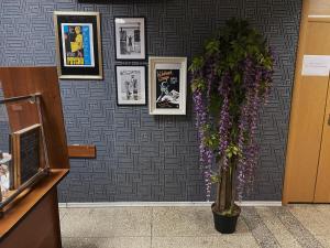a vase with purple flowers on a wall with pictures at Hostel on Komsomolskaya in Sochi