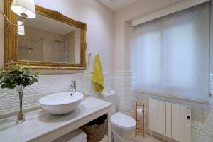 a bathroom with a sink and a toilet and a mirror at Casa Portolago in Carballo +25 photos