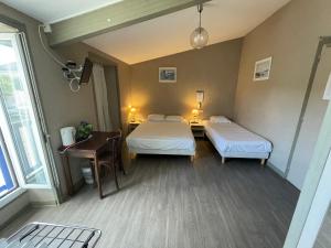 Un pat sau paturi într-o cameră la Logis hôtel Le Terminus