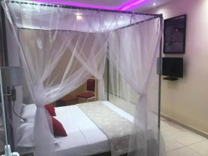 a bed with a canopy in a room at Club saft saly niakhal niakhal in Mbour