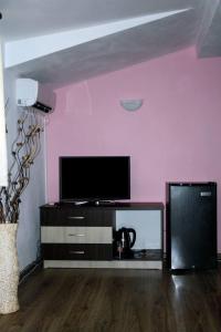 a living room with a flat screen tv on a wall at Guest House Bulgari in Kazanlŭk