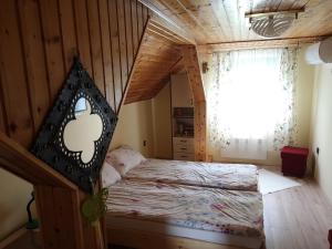 een slaapkamer met een bed in een houten kamer bij Szabó Vendégház in Siklós