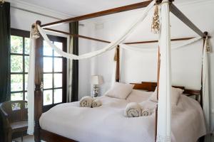 sypialnia z łóżkiem z baldachimem i ręcznikami w obiekcie Huge Golf and Spa Mansion 8 min from Puerto Banus w mieście Estepona +37 zdjęć