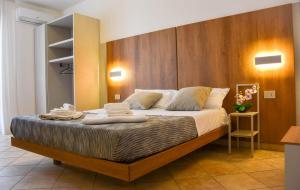 a bedroom with a large bed with two towels on it at Hotel Sikania in San Vito lo Capo