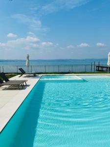 a blue swimming pool with a view of the ocean at Villa Pioppi Hotel in Sirmione