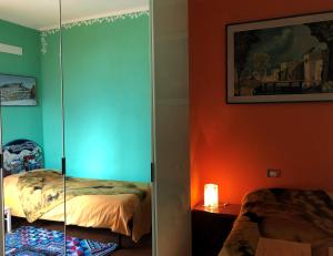 Oliveto LarioにあるB&B L'ericaの緑とオレンジの壁のベッドルーム1室、ベッド1台が備わります。