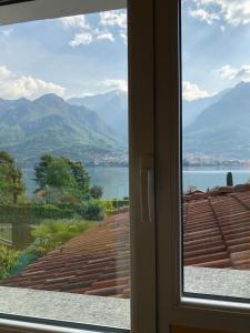 ein Fenster mit Blick auf das Wasser und die Berge in der Unterkunft B&B L'erica in Oliveto Lario