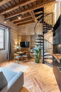 a living room with a spiral staircase in a loft at Santa Clara Suites Sevilla in Seville