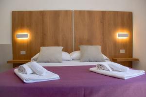 a large bed with two white towels on it at Hotel Sikania in San Vito lo Capo