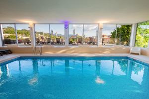 a large swimming pool with blue water and windows at Luna Arcos Hotel Nature & Wellness in Arcos de Valdevez