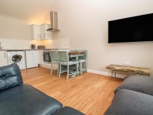 a living room with a couch and a flat screen tv at The Shed at Gweal-an-Drea in Helston