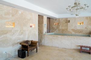 Pokój z krzesłem i lustrem na ścianie w obiekcie Huge Golf and Spa Mansion 8 min from Puerto Banus w mieście Estepona