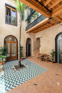 un patio con una palmera y un edificio en Santa Clara Suites Sevilla, en Sevilla