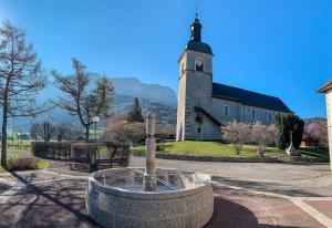 eine Kirche mit einem Brunnen davor in der Unterkunft Studio plein sud, Wifi, Parking in Thollon