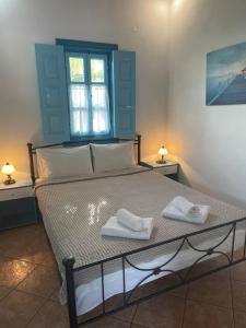 a bedroom with a bed with two towels on it at Patmos Villas in Grikos