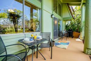a patio with a table and chairs and windows at Puamana 6B in Princeville